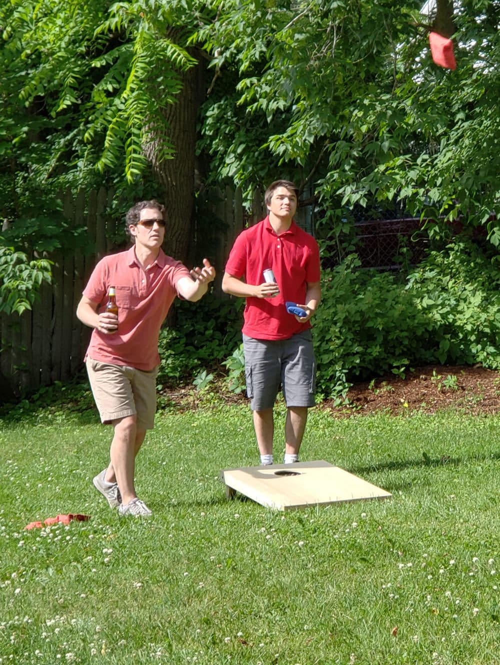 having fun at work playing cornhole and drinking a beer