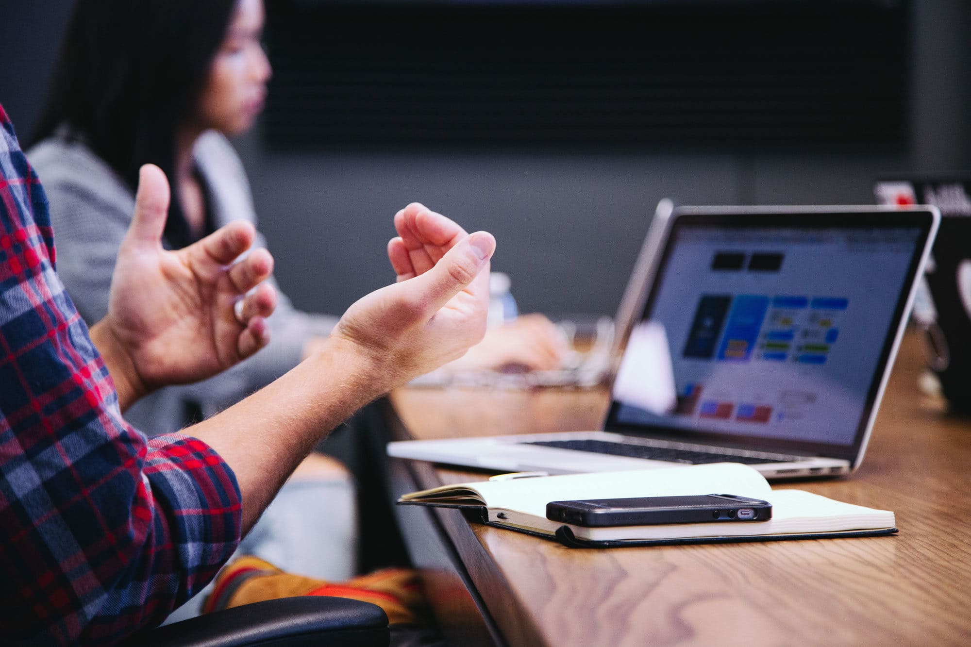 hands gesturing while explaining something at a desk