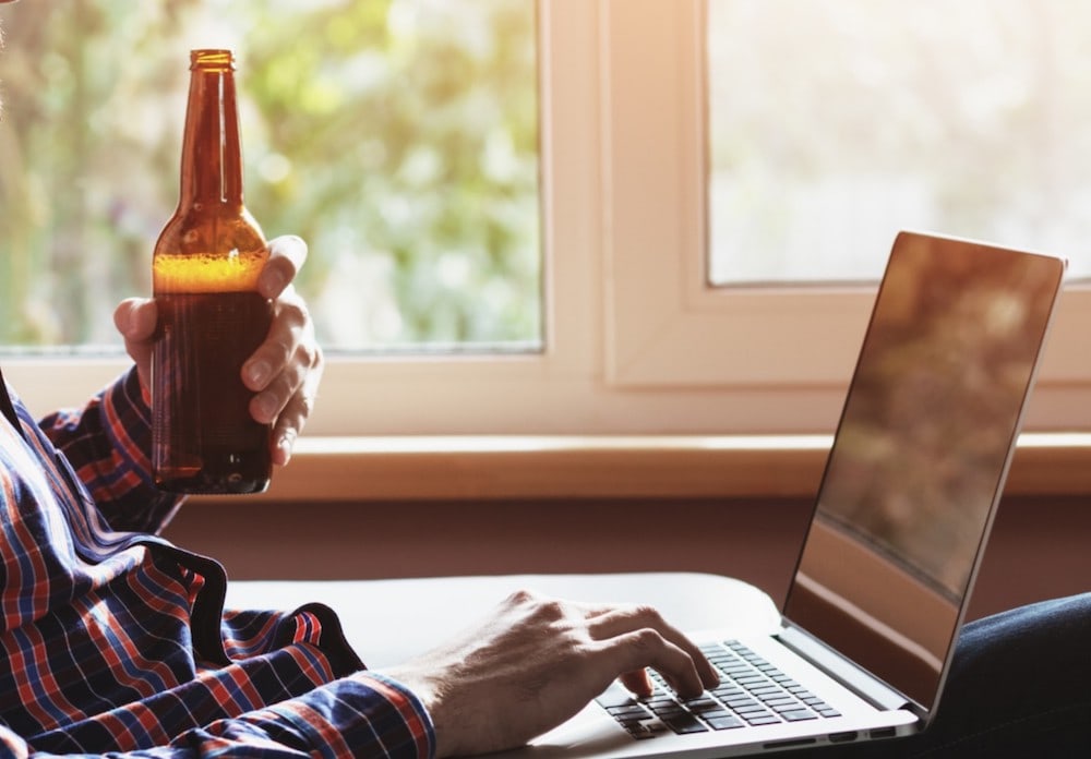 Man Holding Beer at Computer
