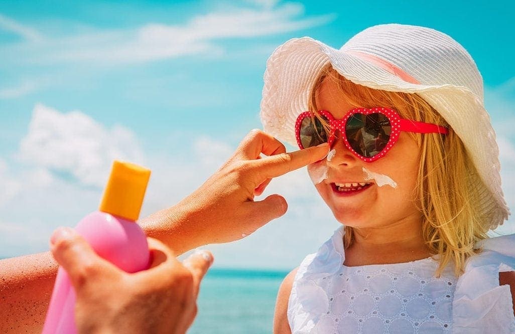 Parent Putting Sunscreen on Child