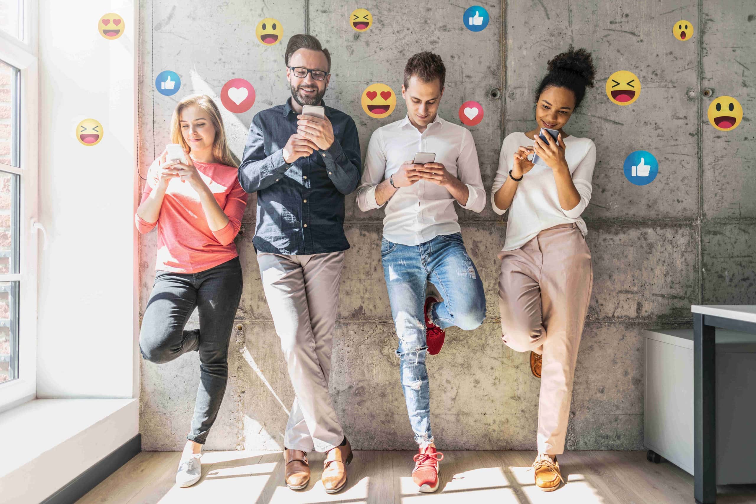 four people on their phones surrounded by facebook emojis