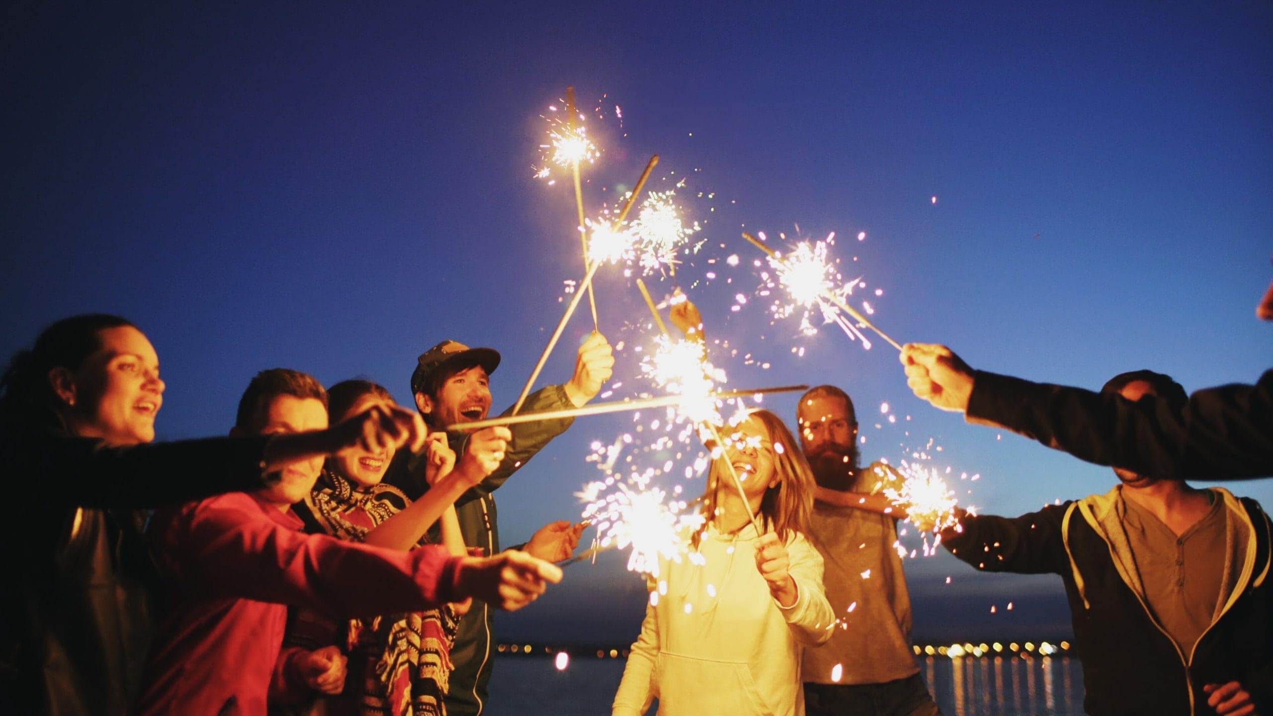 group of people holding sparklers outside
