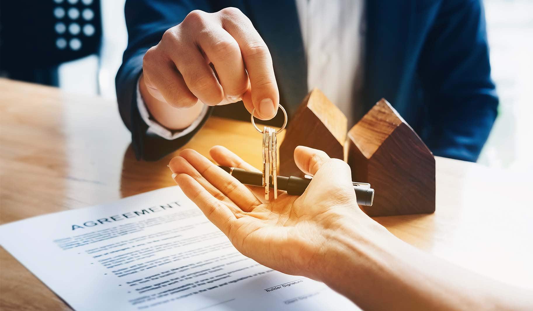 real estate agent handing keys to a homebuyer