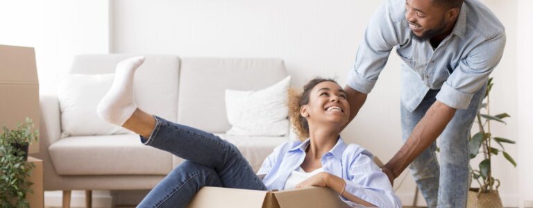 young couple moving into a house with woman in box