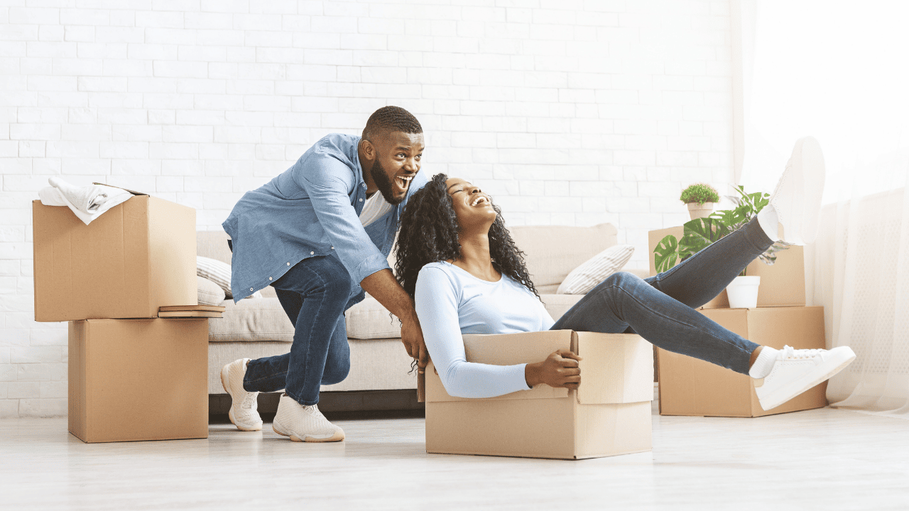 man pushing woman sitting in cardboard box
