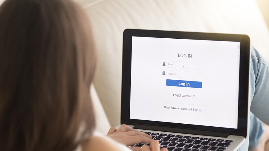woman with laptop and forced registration popup on screen