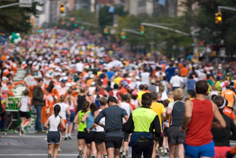large group of people running a marathon in a city