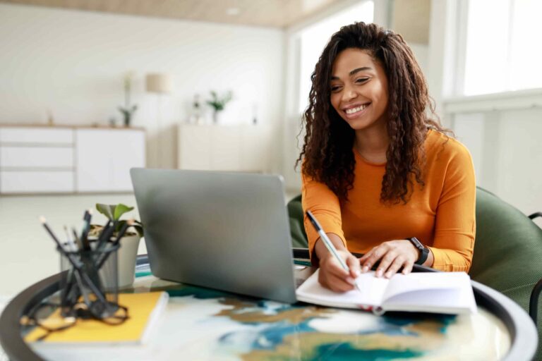 woman sitting at text with computer and notebook